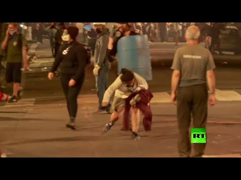 امرأة تسقط على الأرض متأثرة بغازات الشرطة في بورتلاند الأميركية