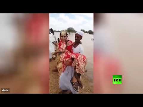 عريس يحمل عروسته فوق السيول في أحد المدن السودانية