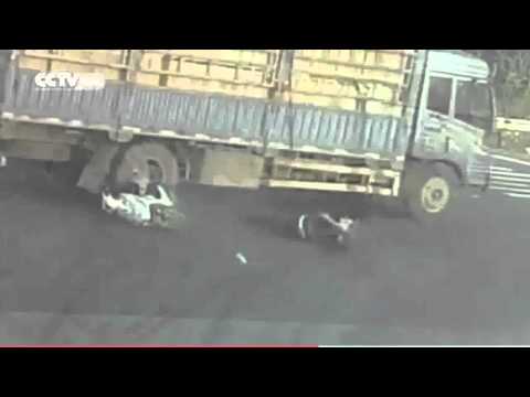 قائد دراجة ينجو من الموت دهسًا تحت شاحنة ضخمة